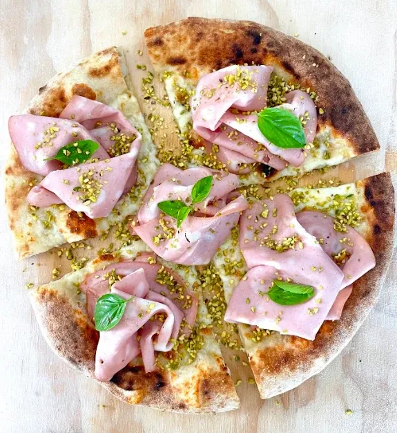 Fermento Pizzaboden belegt mit Mortadella, Pistazien und Basilikum